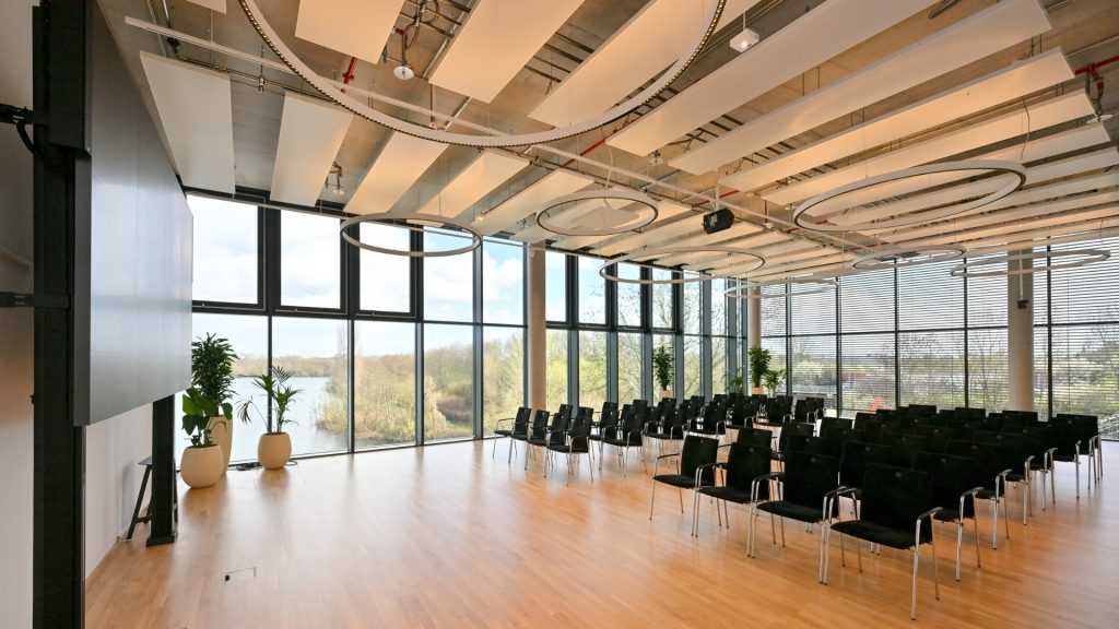 Meetingraum Eventlocation EUREF-Campus Düsseldorf mit Reihen-Bestuhlung und Fensterfront mit Seeblick