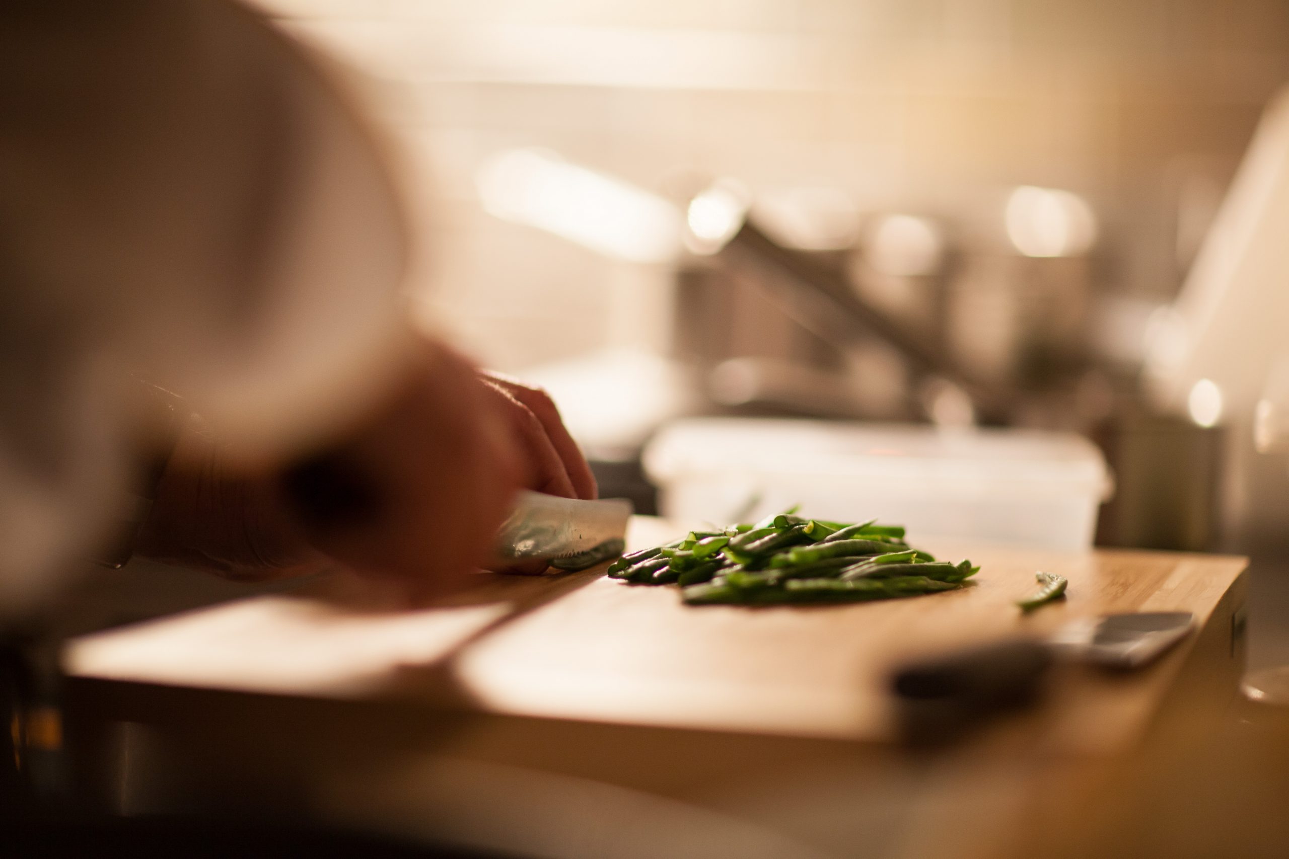 Zwei Hände schneiden Gemüse