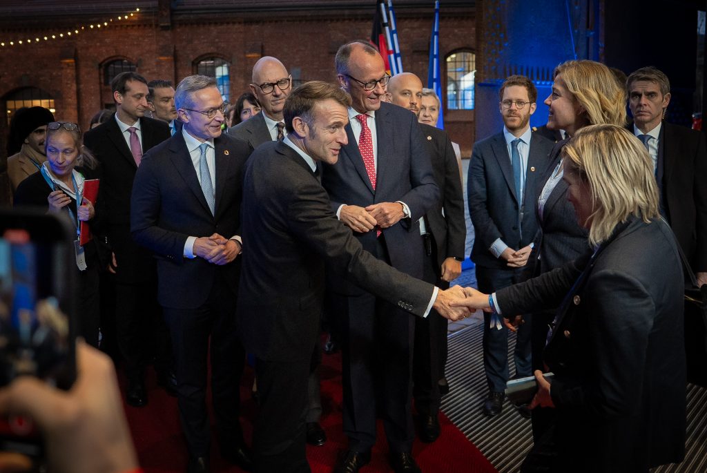 Der französische Präsident Emmanuel Macron begrüßt andere Gäste mit Handschlag