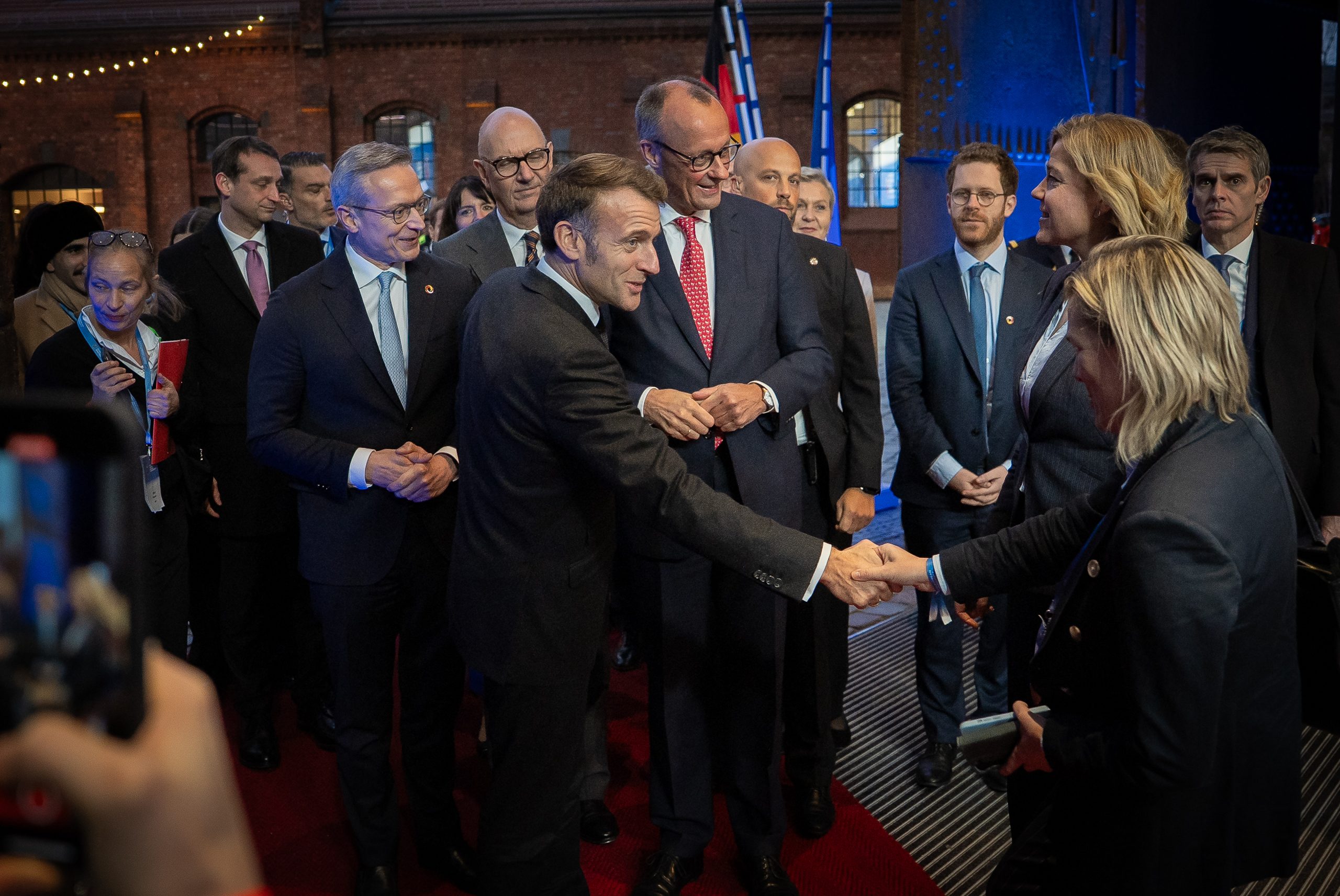 Der französische Präsident Emmanuel Macron begrüßt andere Gäste mit Handschlag