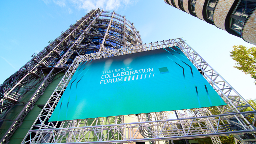 Gasometer mit LED-Wans im Vordergrund auf der das Logo der BMW Foundation zu sehen ist.