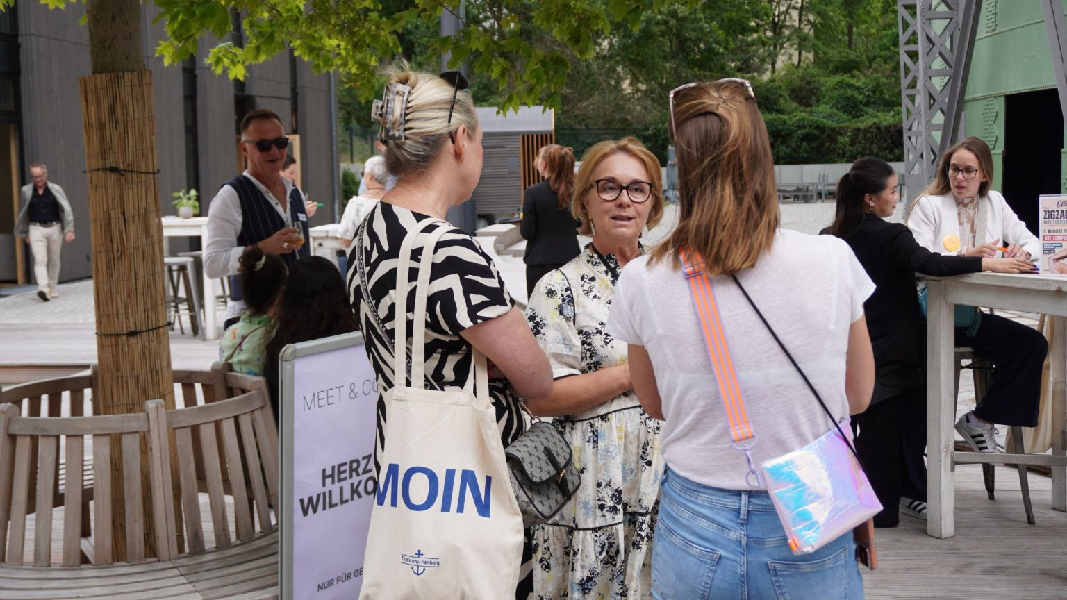 Drei Frauen unterhalten sich unter einem Baum stehend