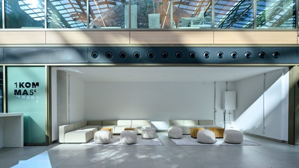 Das Atrium auf dem EUREF-Campus mit modernem Mobiliar und Sitzmöglichkeiten