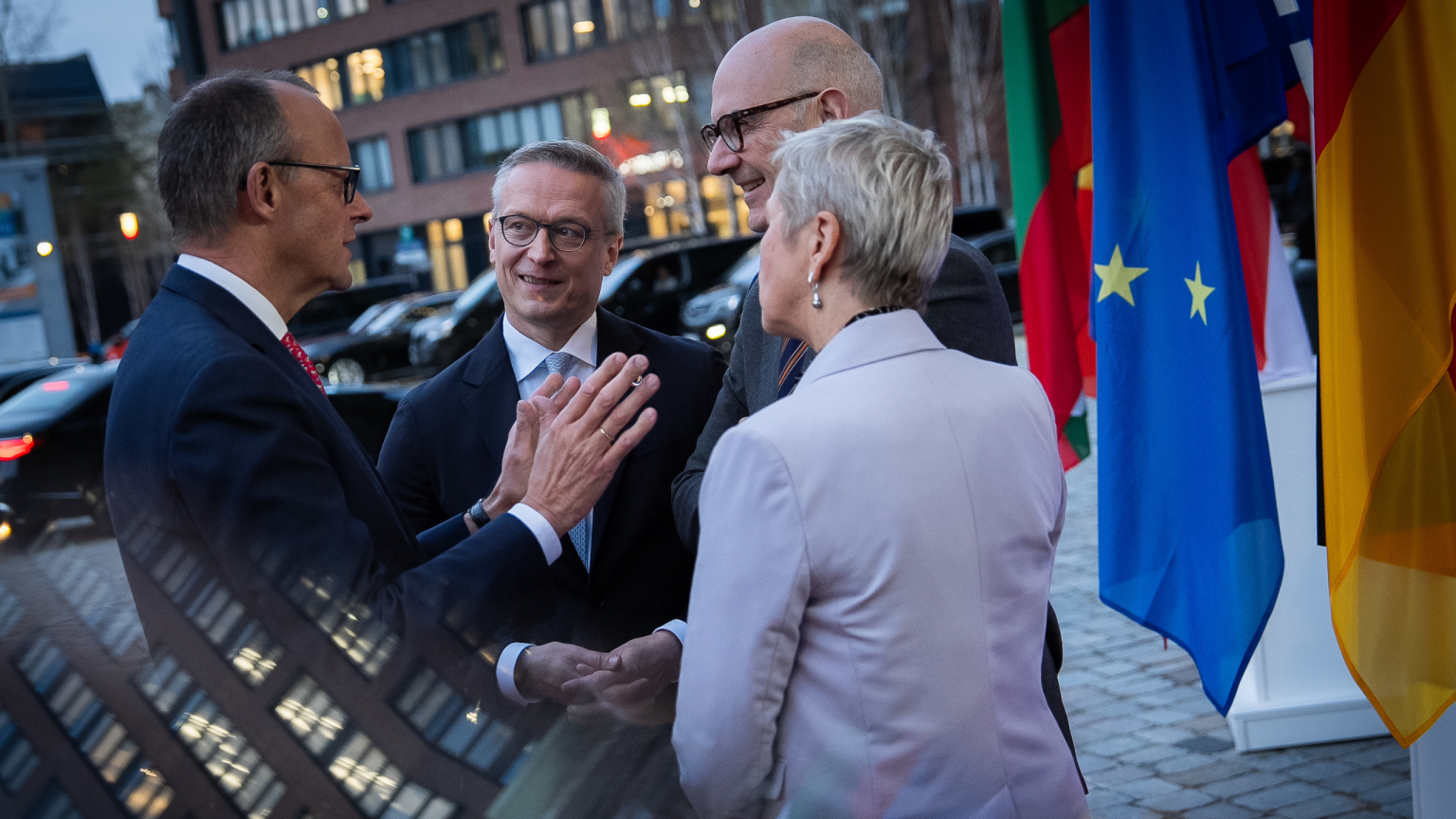 Karsten Wildberger und Anne Le Hénanff im Gespräch mit Kanzler Friedrich Merz vor dem Eingang des Gasometers