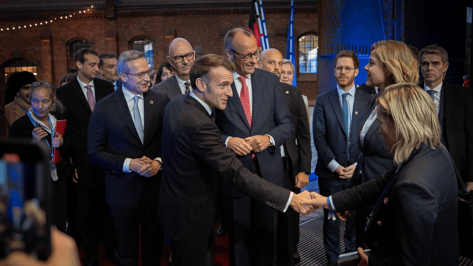 Der französische Präsident Emmanuel Macron begrüßt andere Gäste mit Handschlag