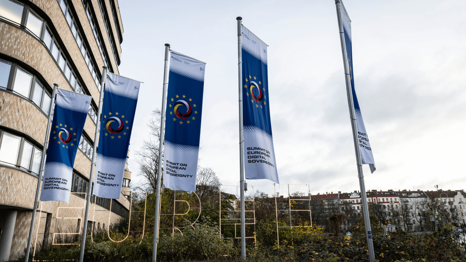Vor dem EUREF-Campus Berlin wehen Fahnen des Digital-Gipfels
