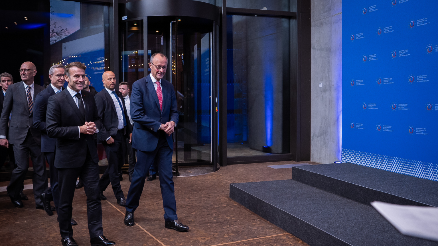 Bundeskanzler Friedrich Merz und Frankreichs Präsident Emmanuel Macrons betreten die Lobby des Gasometers