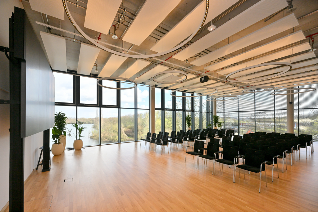 Meetingraum Eventlocation EUREF-Campus Düsseldorf mit Reihen-Bestuhlung und Fensterfront mit Seeblick