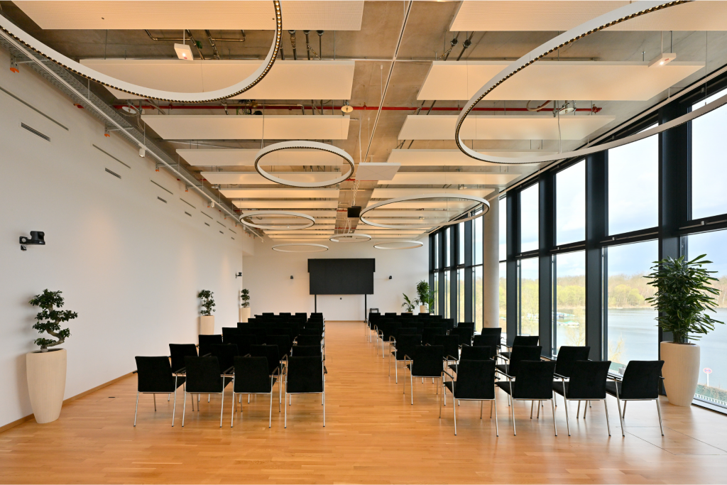 Meetingraum Eventlocation EUREF-Campus Düsseldorf mit Reihen-Bestuhlung und Fensterfront mit Seeblick