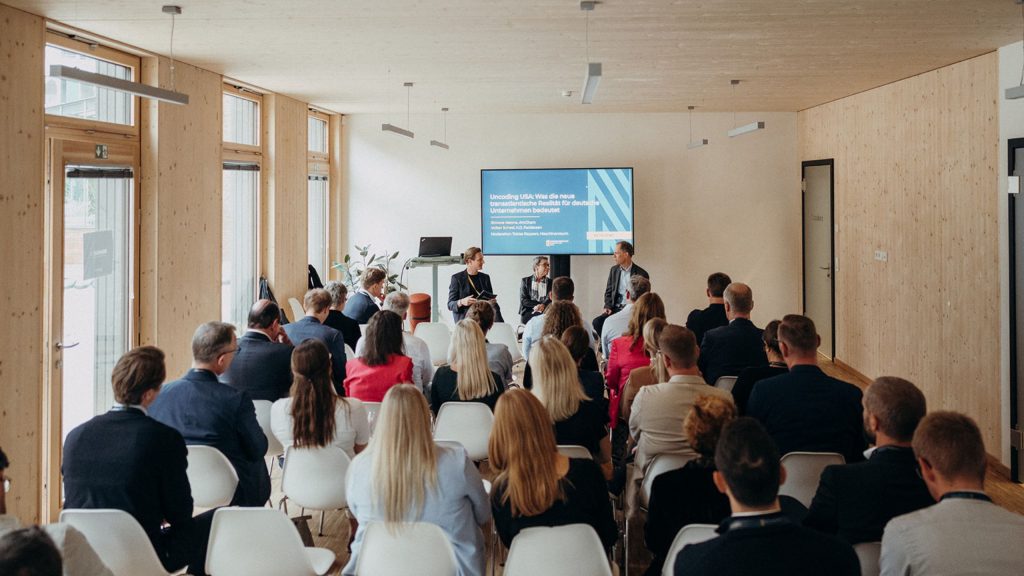 Gäste im Holzhaus bei einem Vortrag