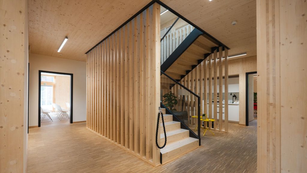 Blick in das Erdgeschoss des Holzhauses, eine offene Treppe führt in das 1. OG