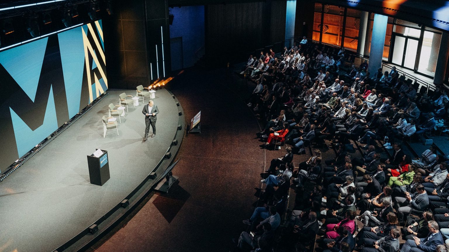 Die MOMENTUM Konferenz von Maschinenraum im Gasometer, der Blick von oben auf die Bühne und das Publikum