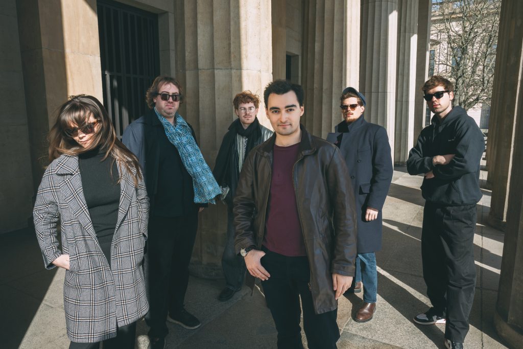 Die Band Junction Ensemble, von links nach rechts: eine Frau und vier Männer stehen vor Säulen für ein Foto ihres Ensembles.