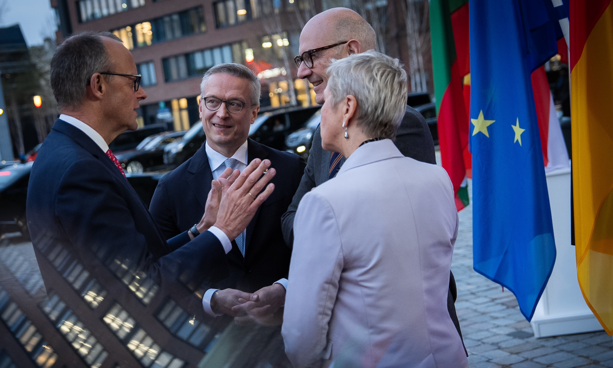 Karsten Wildberger und Anne Le Hénanff im Gespräch mit Kanzler Friedrich Merz vor dem Eingang des Gasometers