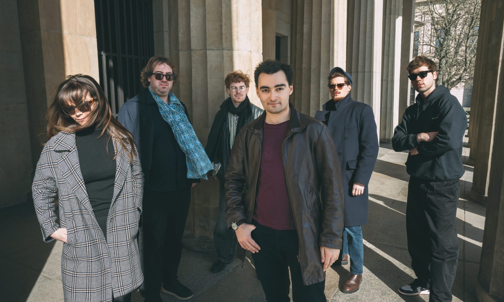 Die Band Junction Ensemble, von links nach rechts: eine Frau und vier Männer stehen vor Säulen für ein Foto ihres Ensembles.