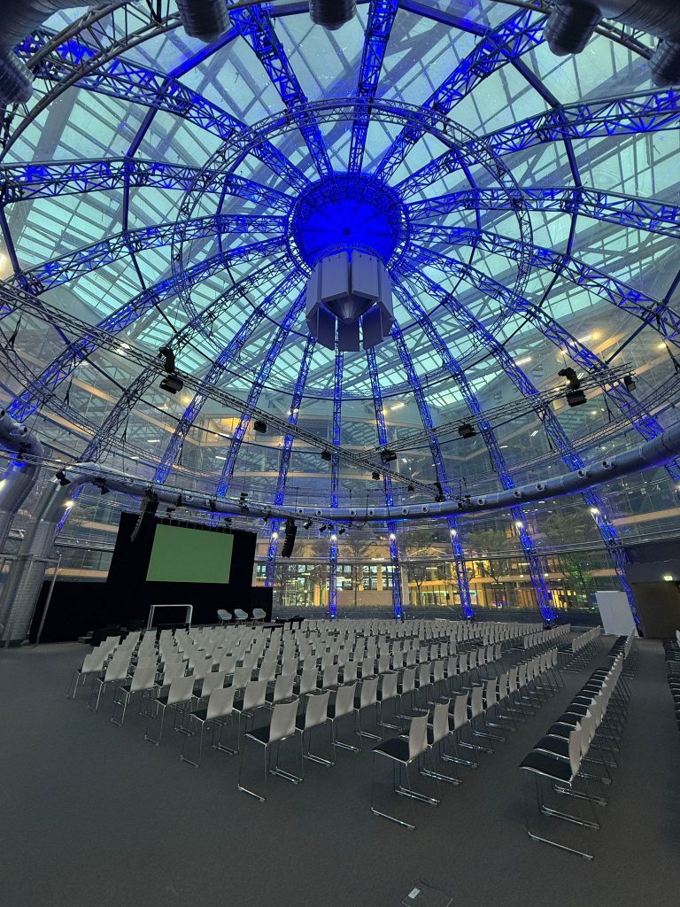 Die EUREF-Kuppel in Düsseldorf, blau beleuchtet und mit weißen Stühlen ausgestattet